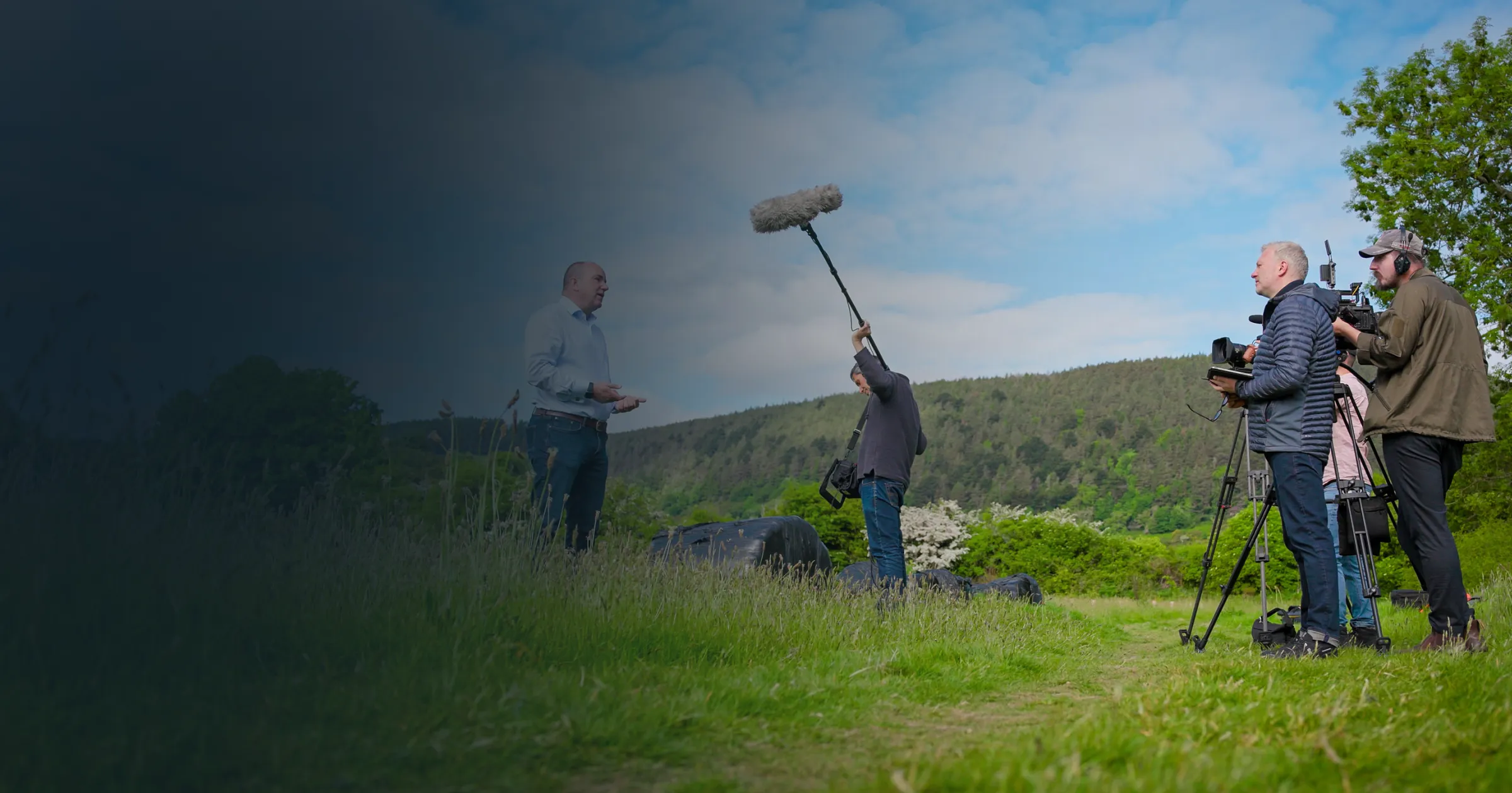 Filming crew in a grassy field with cameras and boom mic, capturing a scene. Text overlay reads: "Behind the Scenes for Limehouse TV." Bright, professional mood.